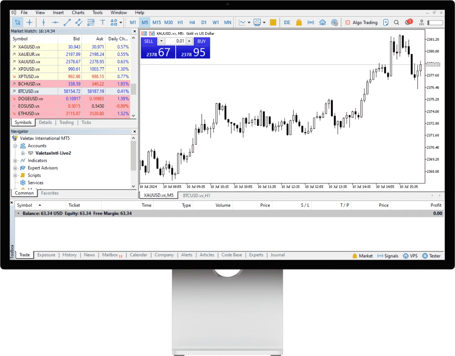 Terminal MetaTrader 5 di monitor desktop dengan grafik XAUUSD dan tab Trade yang menampilkan balance, equity, dan free margin